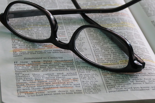 Des lunettes posées sur une page d'un livre avec du texte surligné.